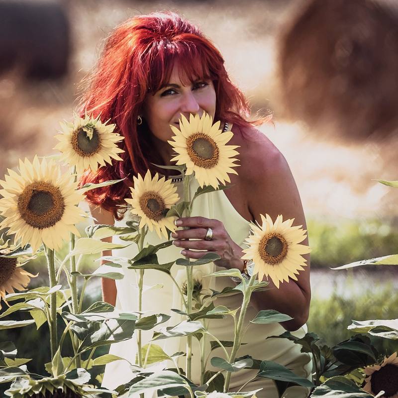 Katka Kapusňák - lektorka tvárovej jógy pózuje so slnečnicami
